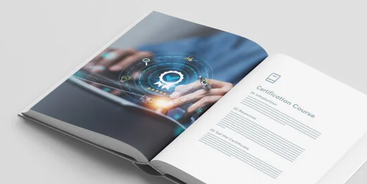 Open booklet lies on a white surface; left page shows hands tapping a tablet with a glowing circular digital interface; right page titled...
