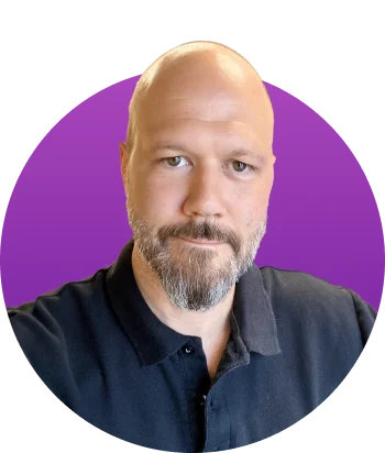 Bald, bearded man gazes directly at camera, wearing a dark polo; portrait presented in a circular crop against a smooth purple gradient background.