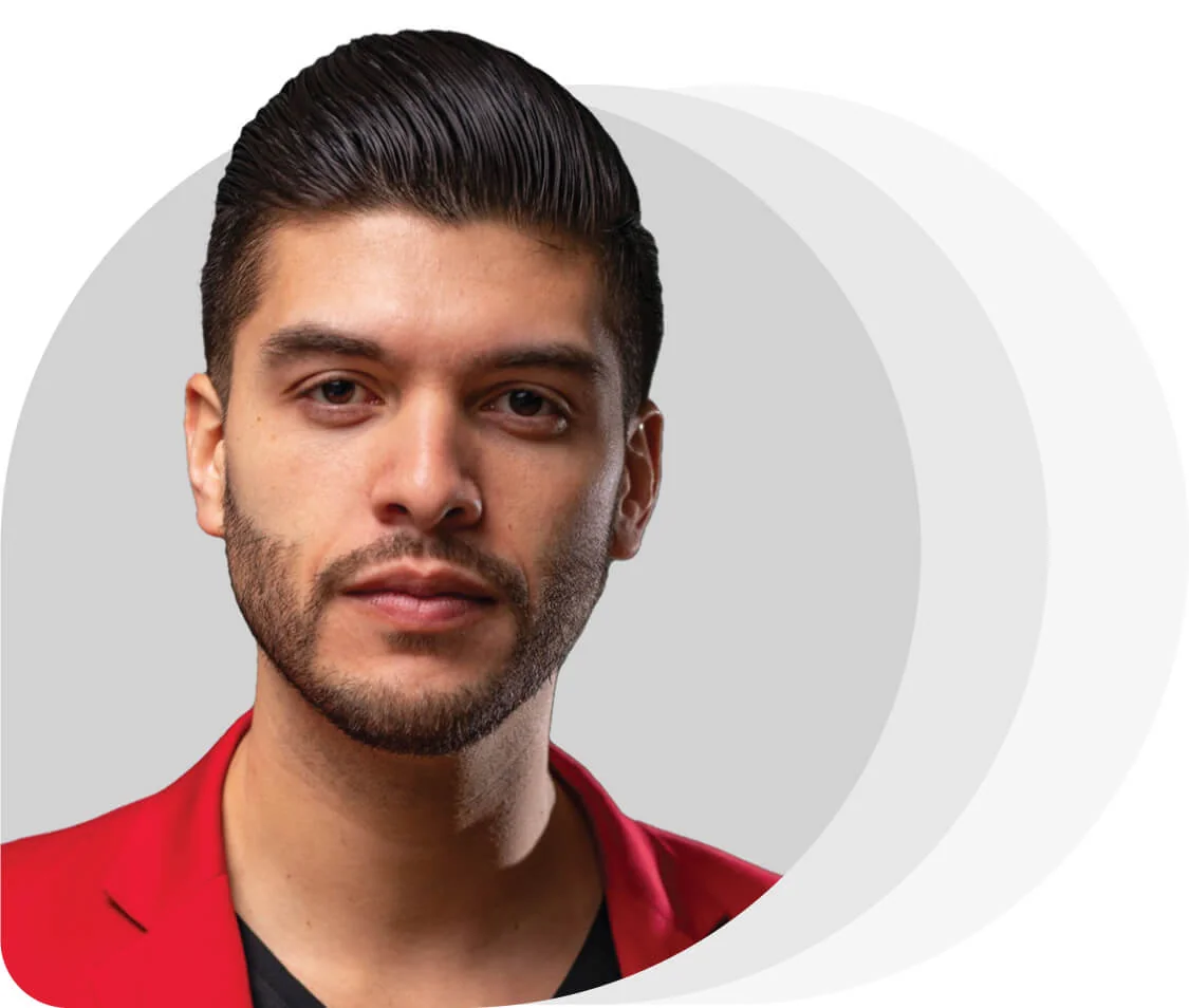 Young man with slicked dark hair and trimmed beard, looking at camera with neutral expression; wearing a red blazer and black shirt in a cropped...