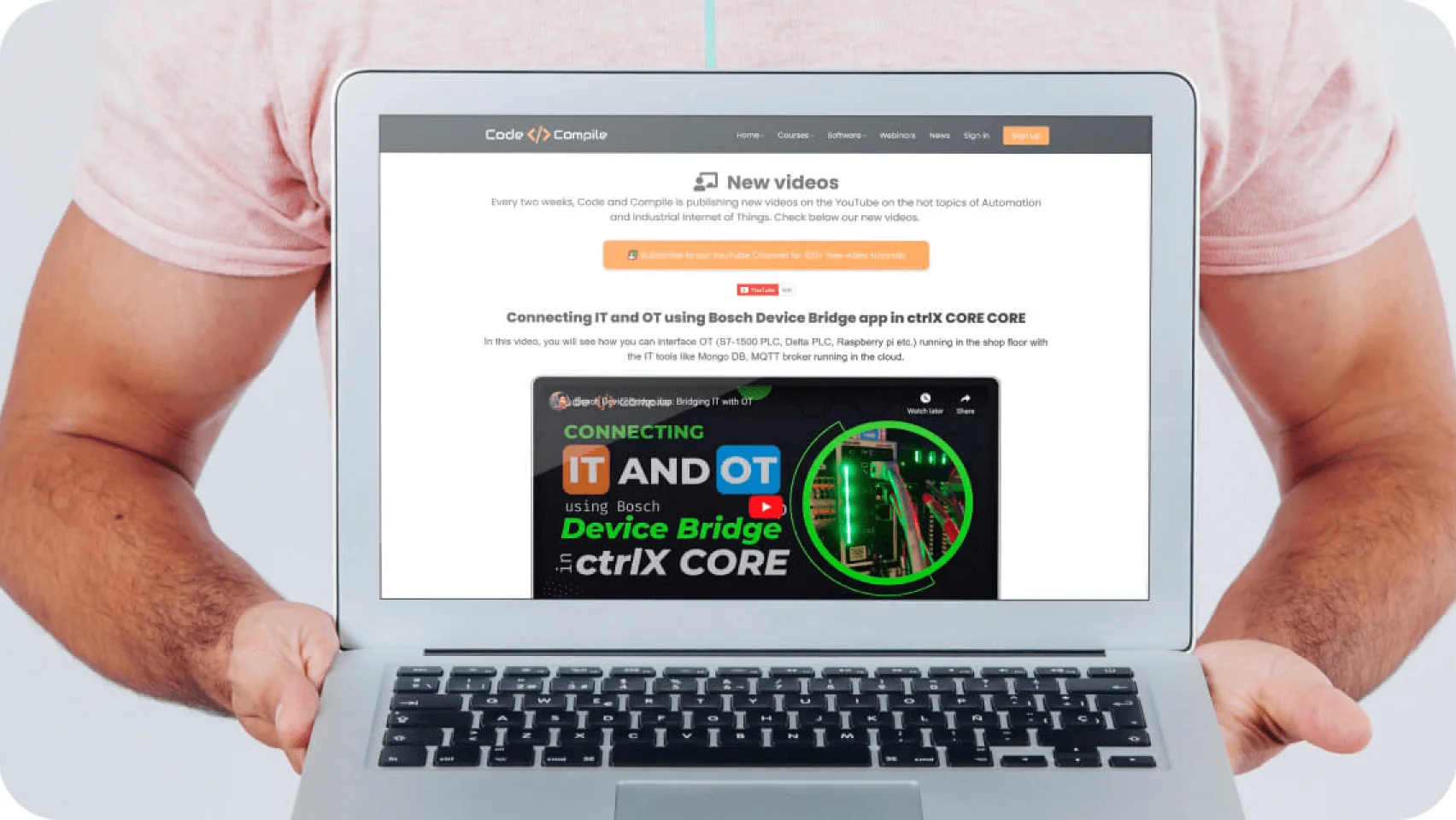 Laptop held by a person, displaying a website page titled "New videos" with a featured video about connecting IT and OT using Bosch Device Bridge in...