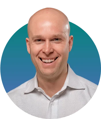 Bald adult man (head-and-shoulders) smiling directly at the camera, wearing a light patterned collared shirt, set against a circular teal-to-blue...