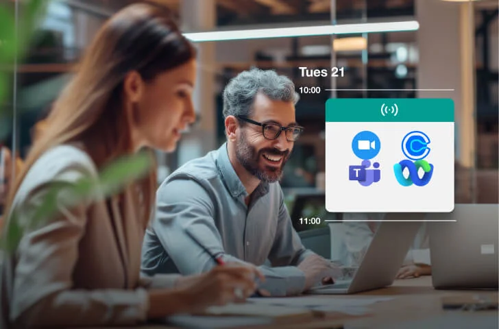 Two coworkers smile and collaborate over laptops in a modern open office; a calendar overlay shows meeting app icons.