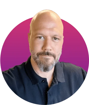 Adult bald man with a short salt-and-pepper beard looks directly at the camera, wearing a dark polo shirt, framed within a circular magenta-to-purple...